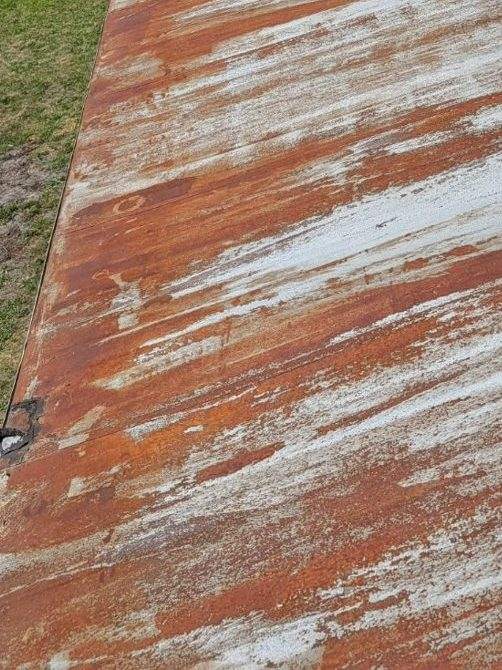 Rusted, weathered metal manufactured-home roof before restoration